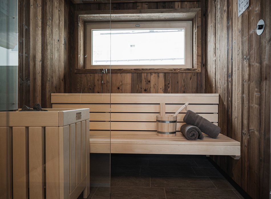 Moderne Sauna mit Holzwänden und Bank in einem Chalet