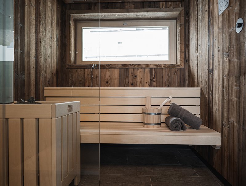 Moderne Sauna mit Holzwänden und Bank in einem Chalet