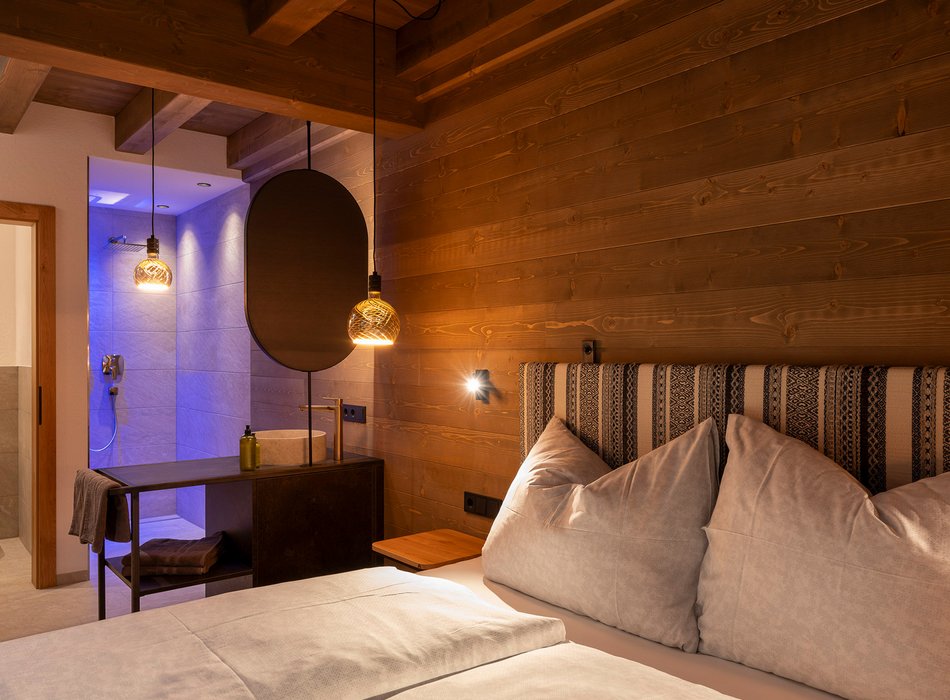 Stilvolles Schlafzimmer im Chalet mit Holzverkleidung und modernen Dusche