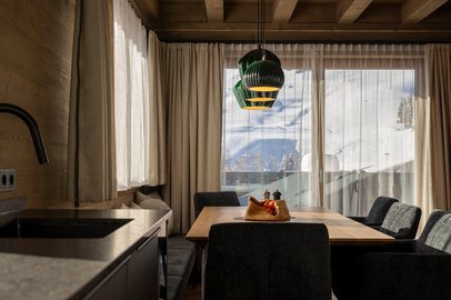 Essbereich im Appartement mit Bergblick durch große Fenster