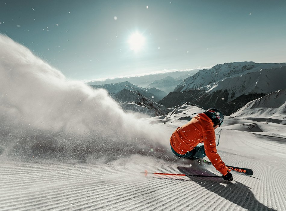Skifahrer in Jacke fährt eine schneebedeckte Piste in Ischgl hinunter