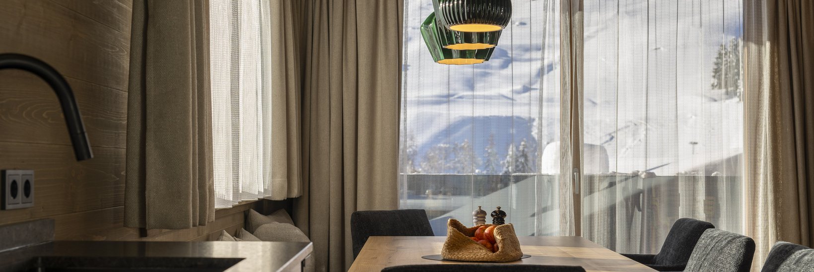 Essbereich mit Holzdekor und Bergblick in einem Chalet von Luf Lodges