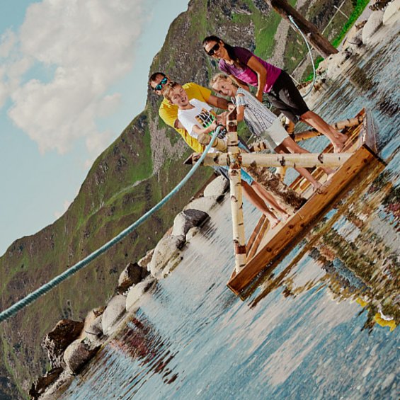 Familie genießt Floßfahrt auf einem Bergsee an einem sonnigen Tag